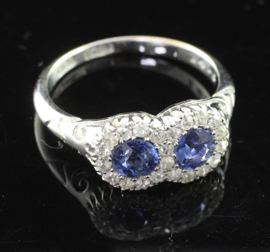 An 18ct white gold sapphire and diamond double cluster ring, size M.